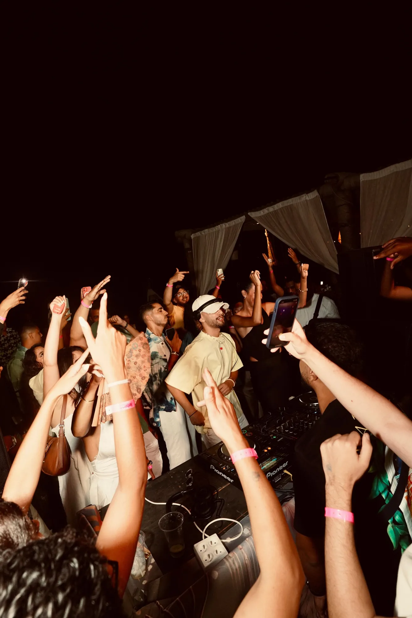 Crowd with hands up in front of the booth