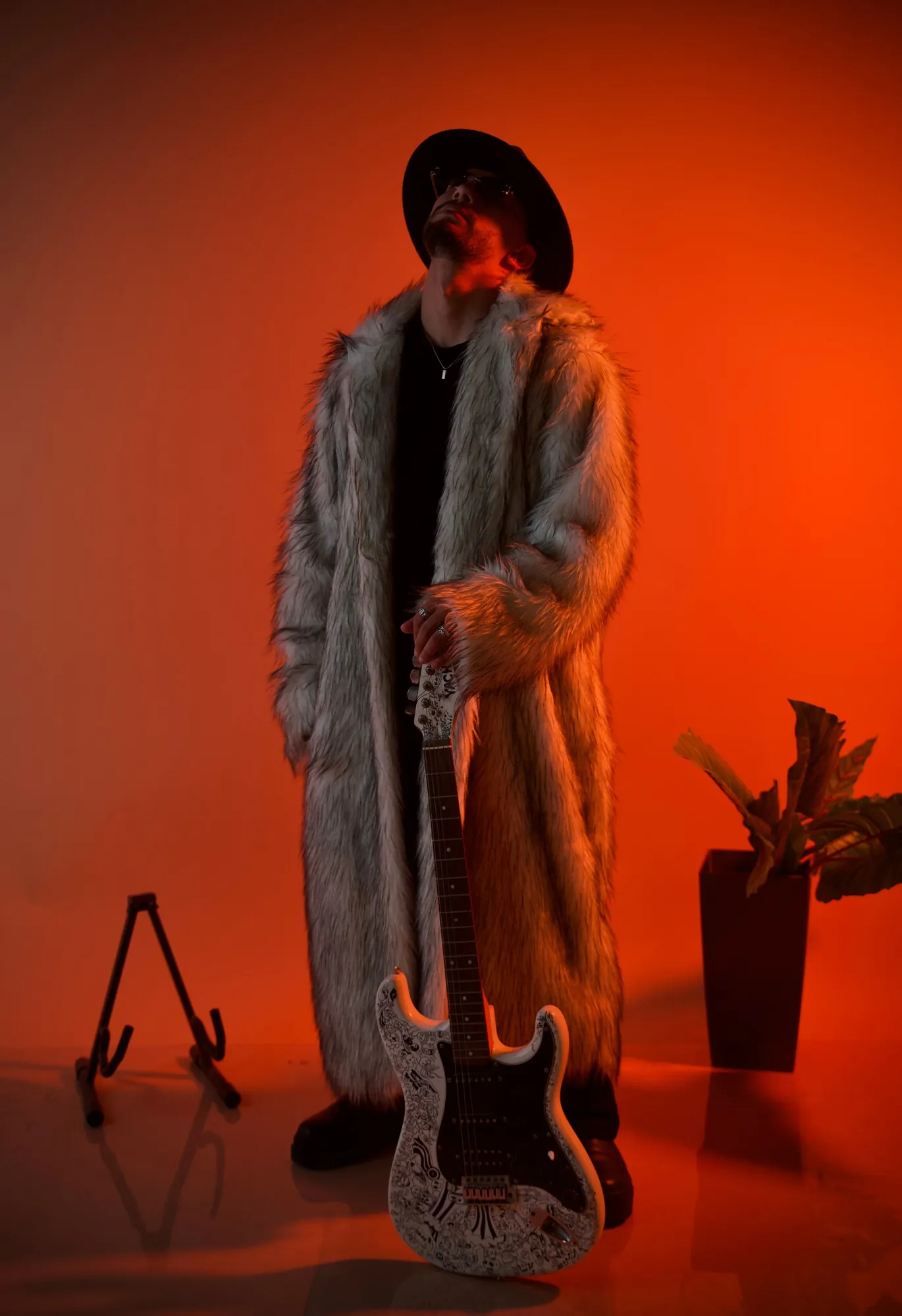 ASHI in a fur coat holding a guitar, studio portrait